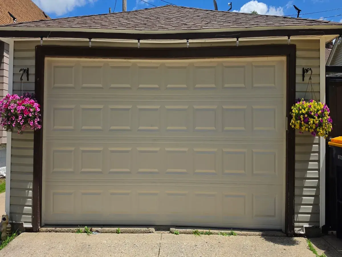 Almond raised panel double garage door on a detached garage