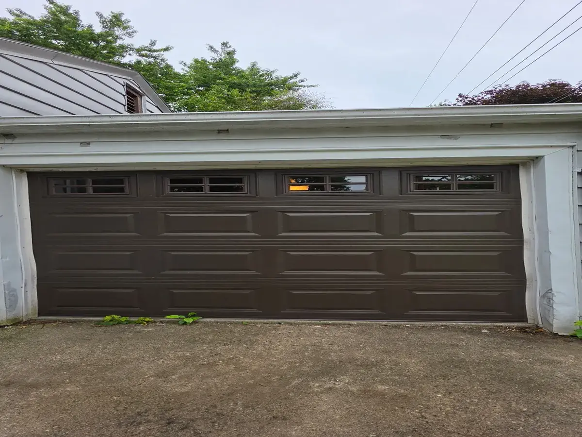 Dark brown garage door with a row of windows on a two car detached garage