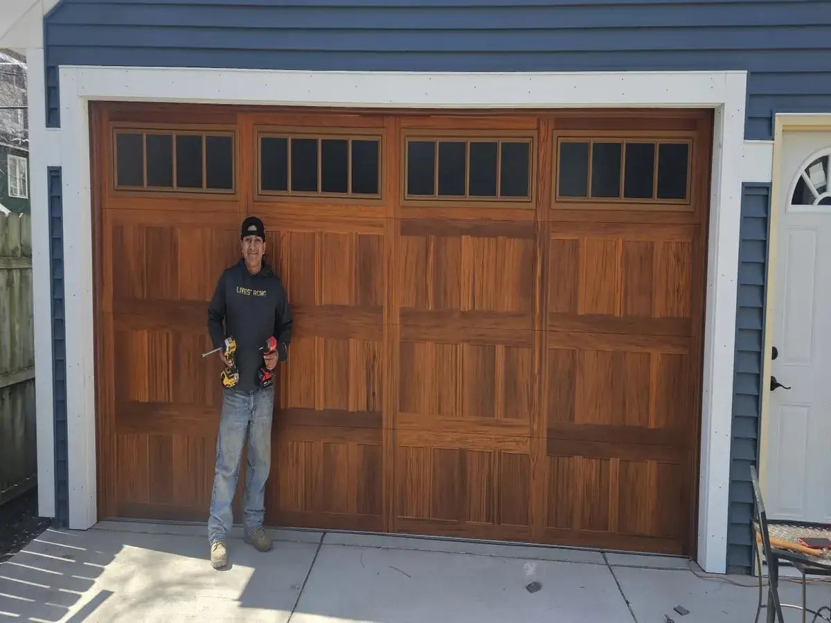 Tavo standing in front of a newly installed wood garage door